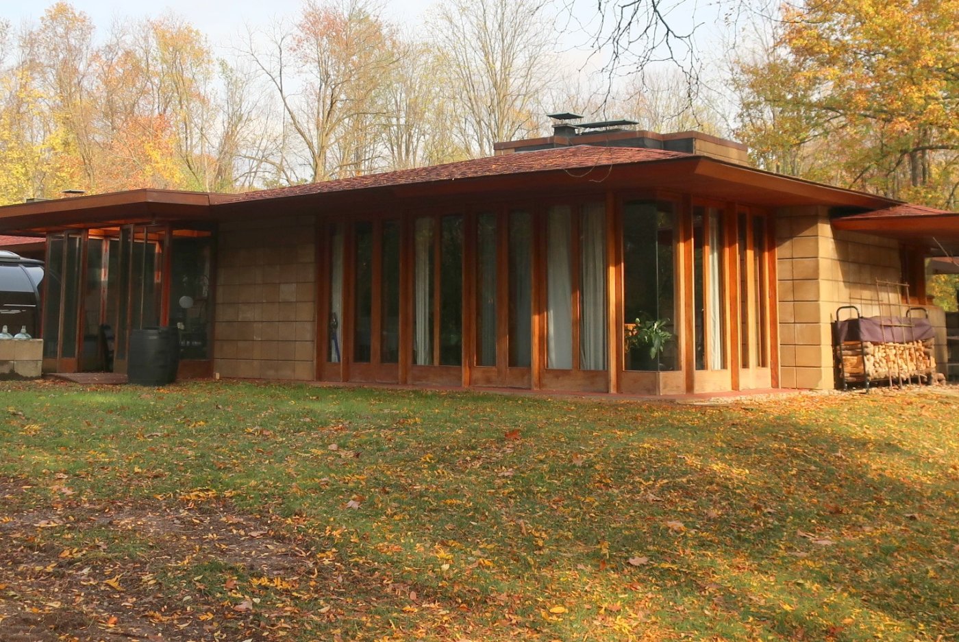 Photo of a one-story house with French doors and hipped roof.